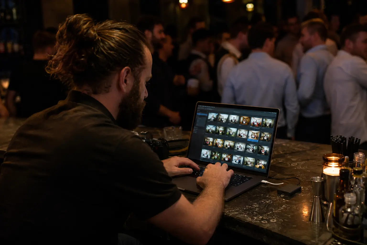 event photographer uploading watch party photos from a laptop during the event